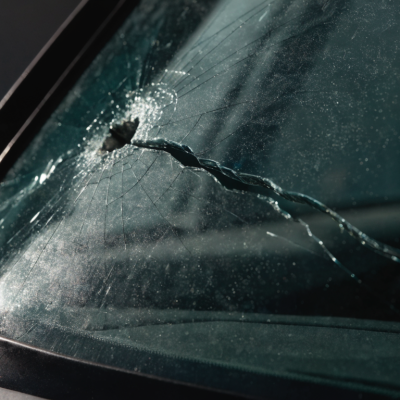 Long crack spreading across a car windshield from an impact point